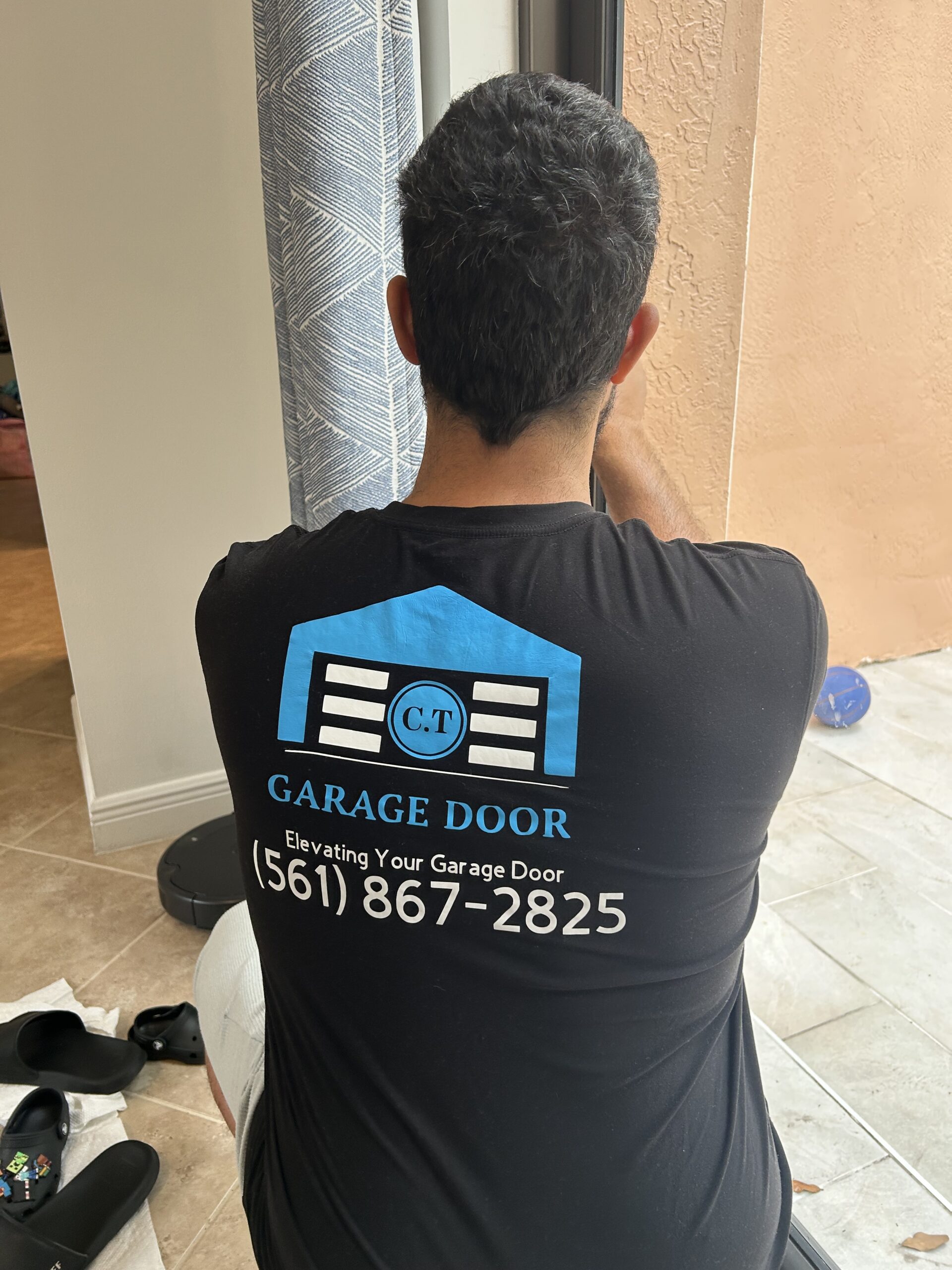 C.T Garage Door technician repairing a sliding glass door in Jupiter, FL