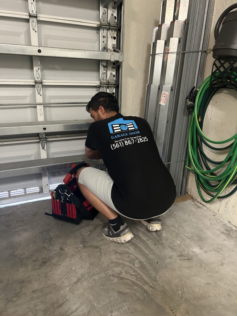 C.T Garage Door technician repairing a garage door